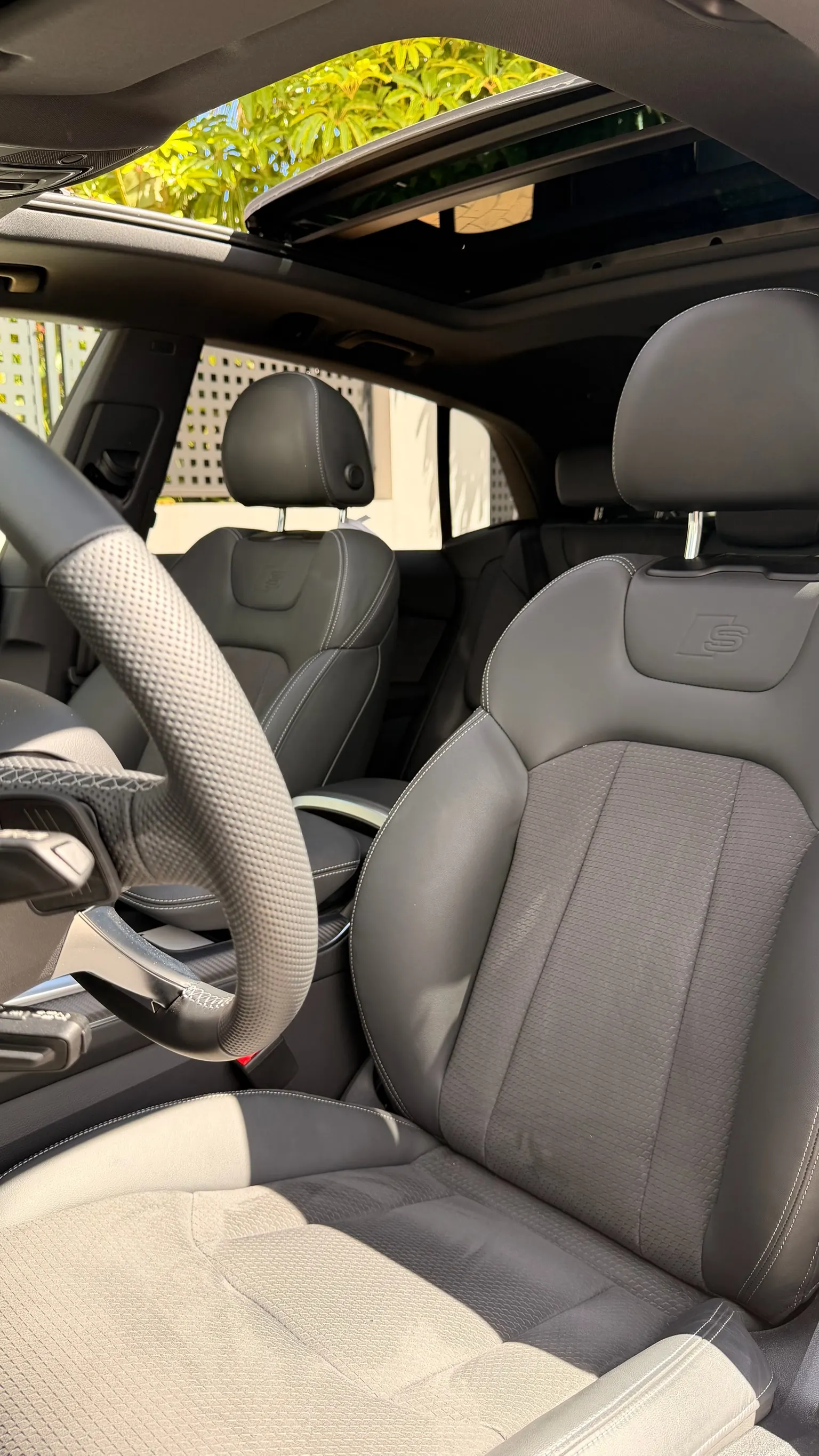 Audi Q8 cockpit with dual MMI touchscreen, 12.3-inch Audi virtual cockpit, flat-bottom S Line steering wheel and panoramic roof open