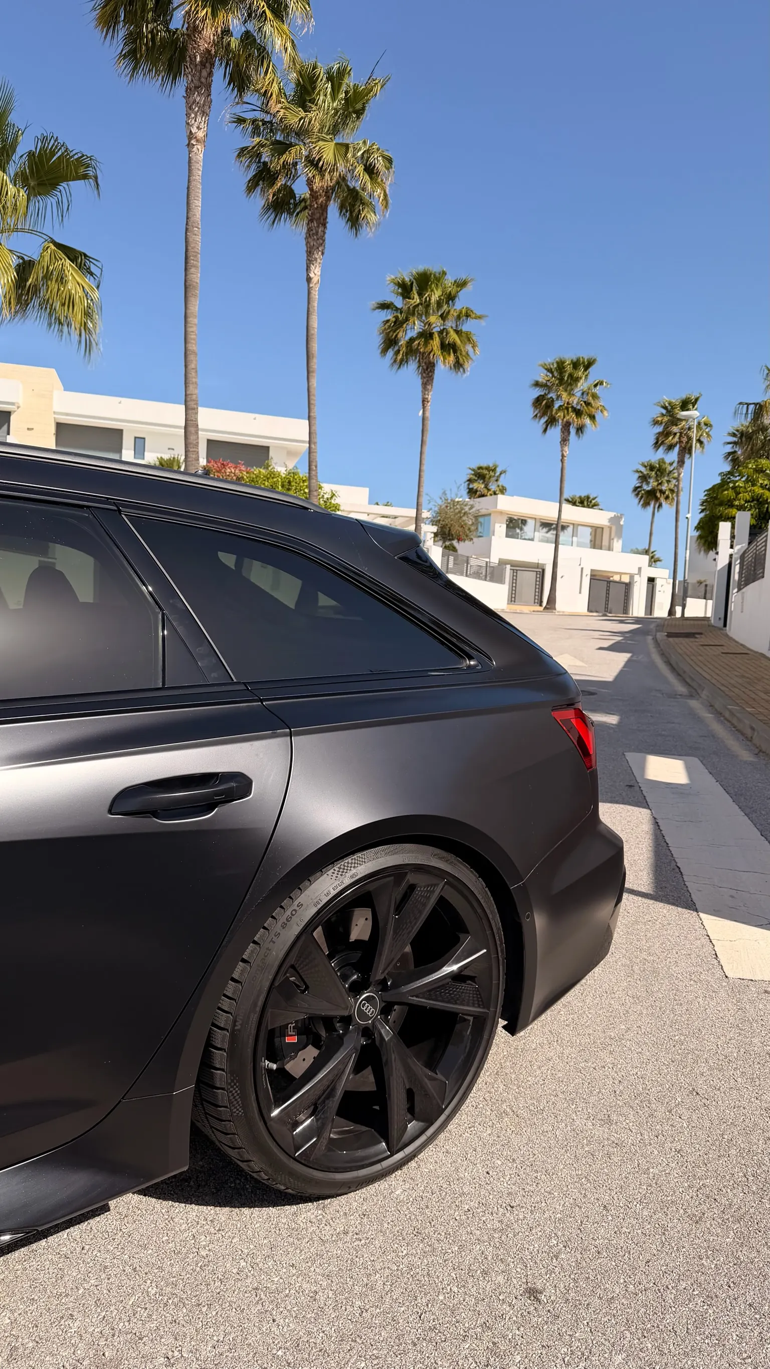 Rear three-quarter view of the Audi RS6 Avant Performance with flared fenders, carbon wheel and RS caliper under Marbella sun