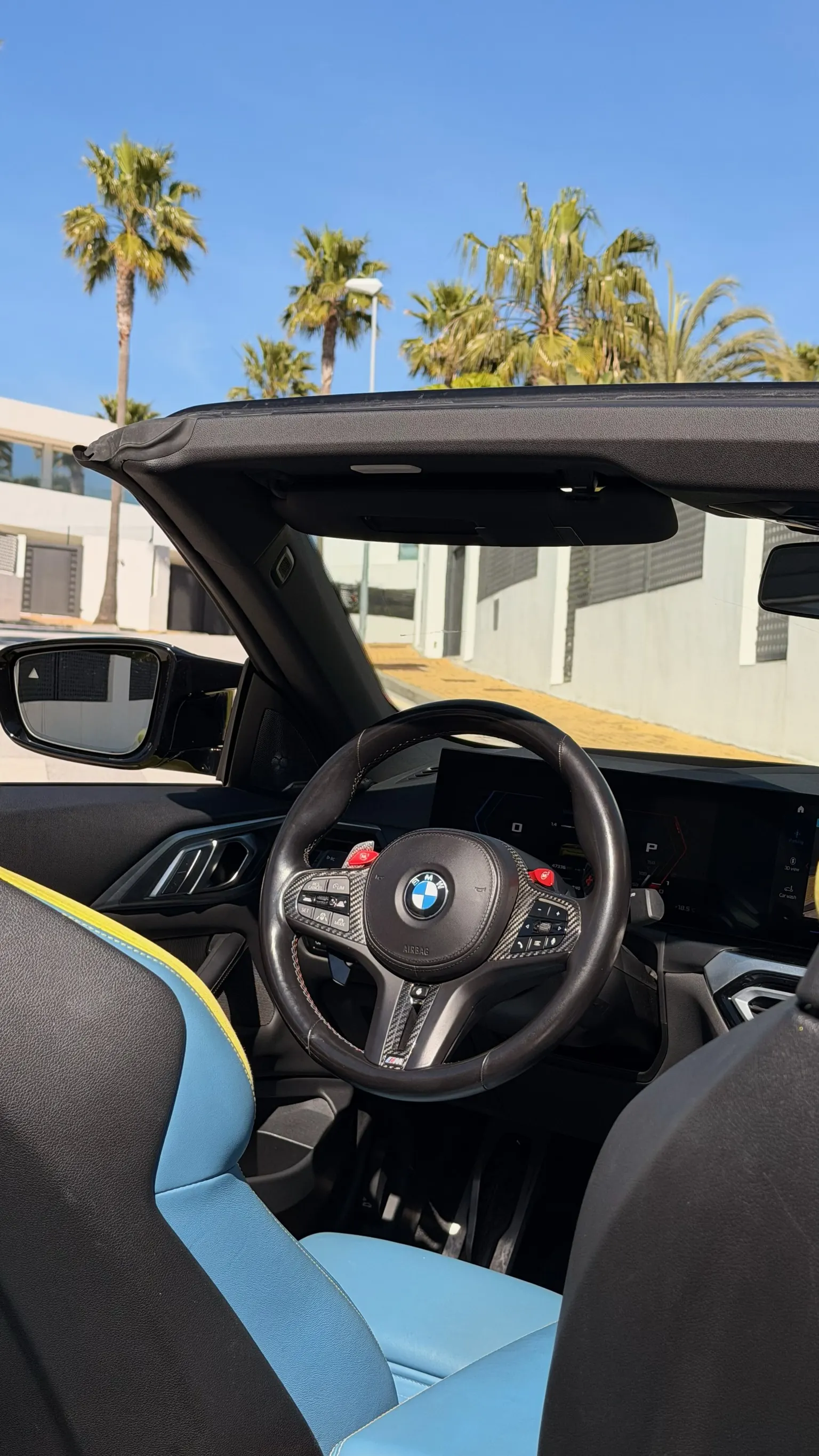 Cabina BMW M4 Cabriolet con volante M de carbono, instrumentación BMW Curved Display y asiento de conductor en cuero azul BMW Individual