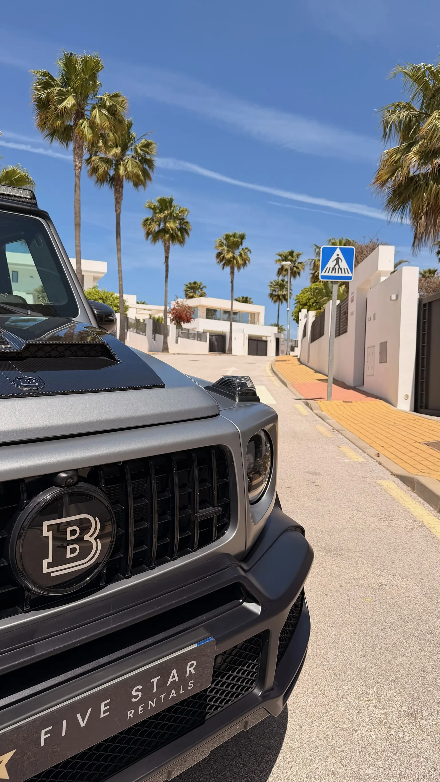 Calandre Brabus avec logo B et plaque Five Star Rentals, capot carbone visible