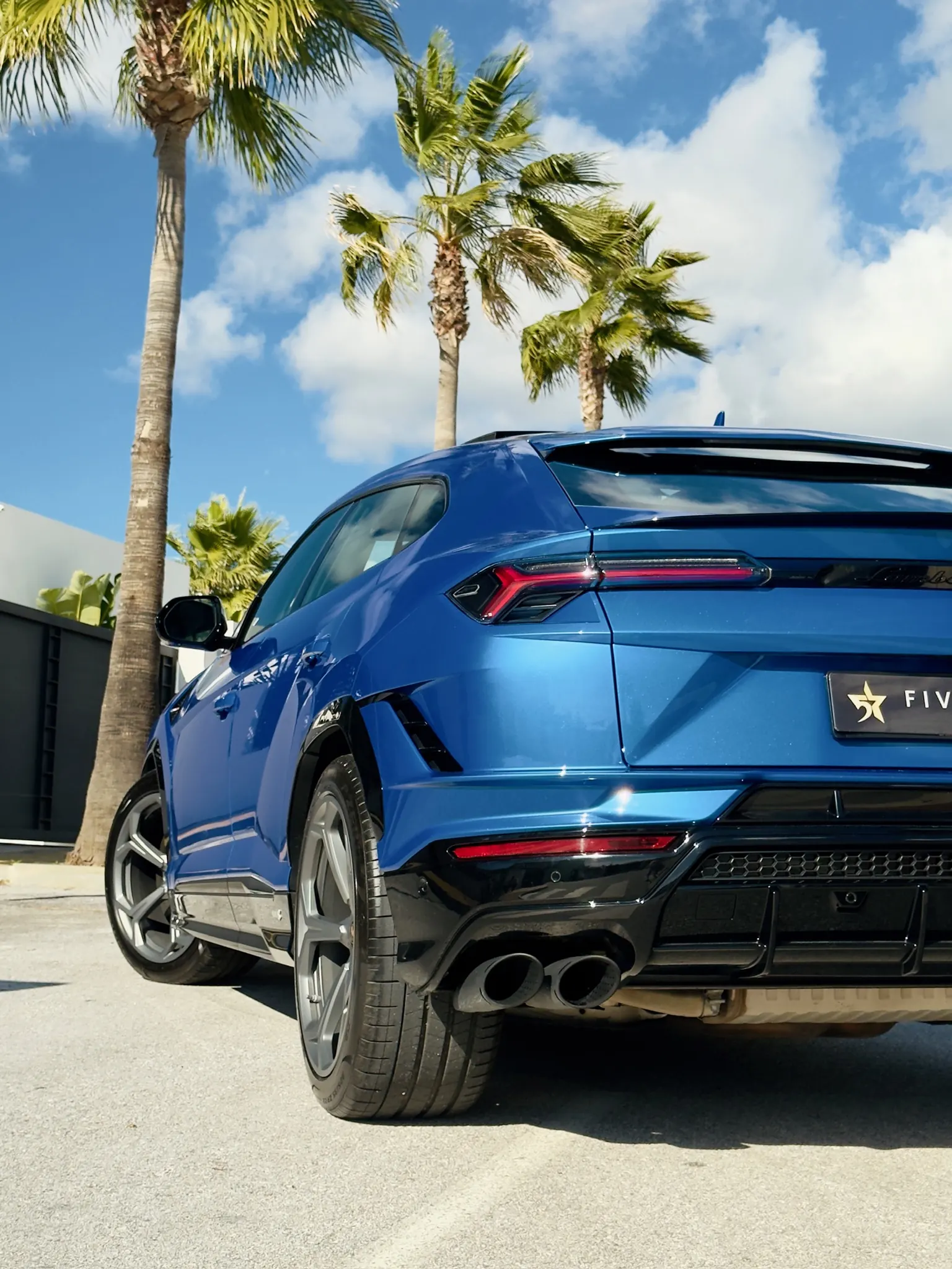 Close-up rear three-quarter view of the Lamborghini Urus S with roof spoiler, Y-shaped LED tail lights, sport diffuser and Five Star Rentals plate