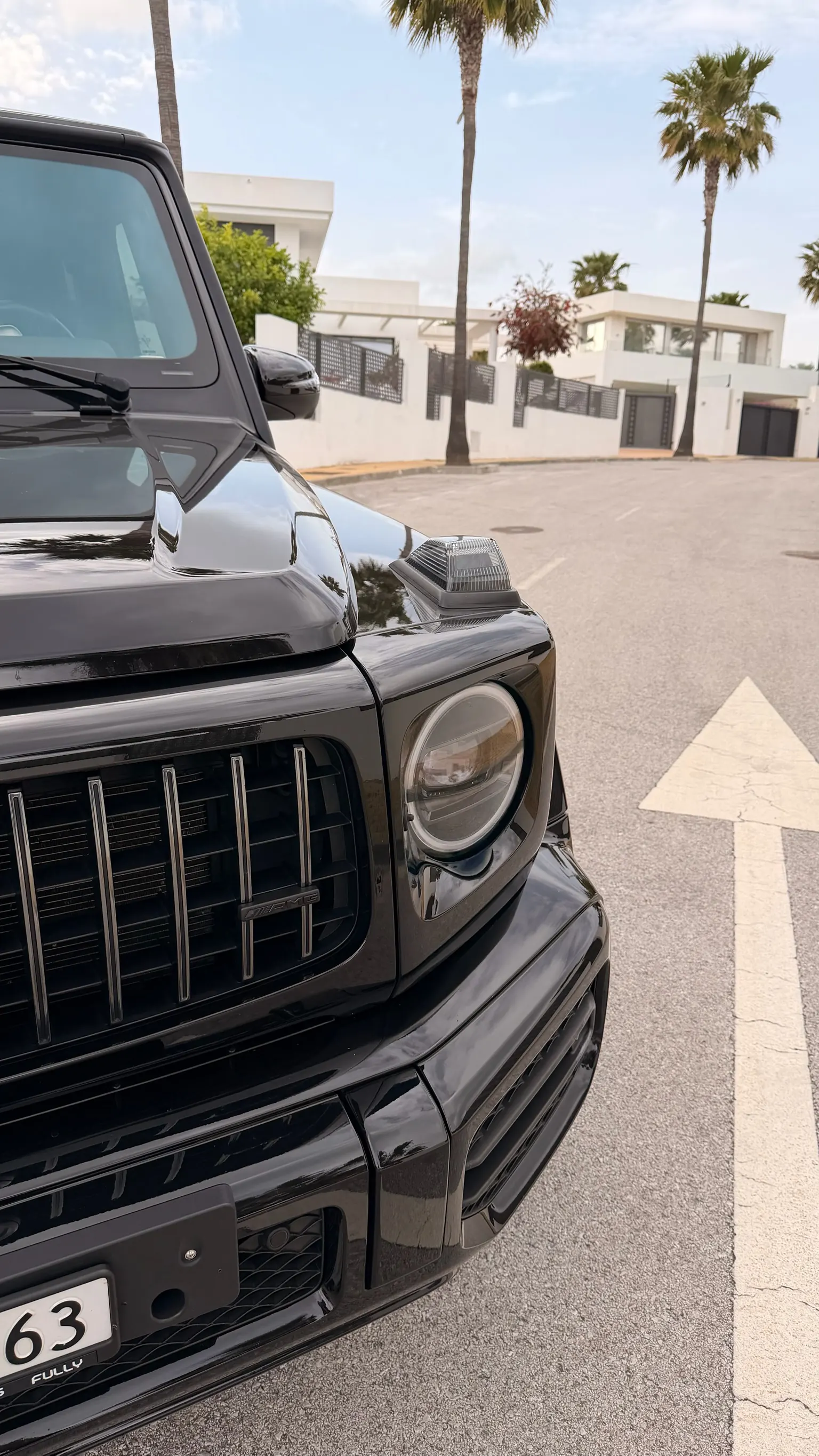 Mercedes-AMG G63 front detail in black with Panamericana grille, AMG badge, fender-mounted indicators and round Multibeam LED headlights