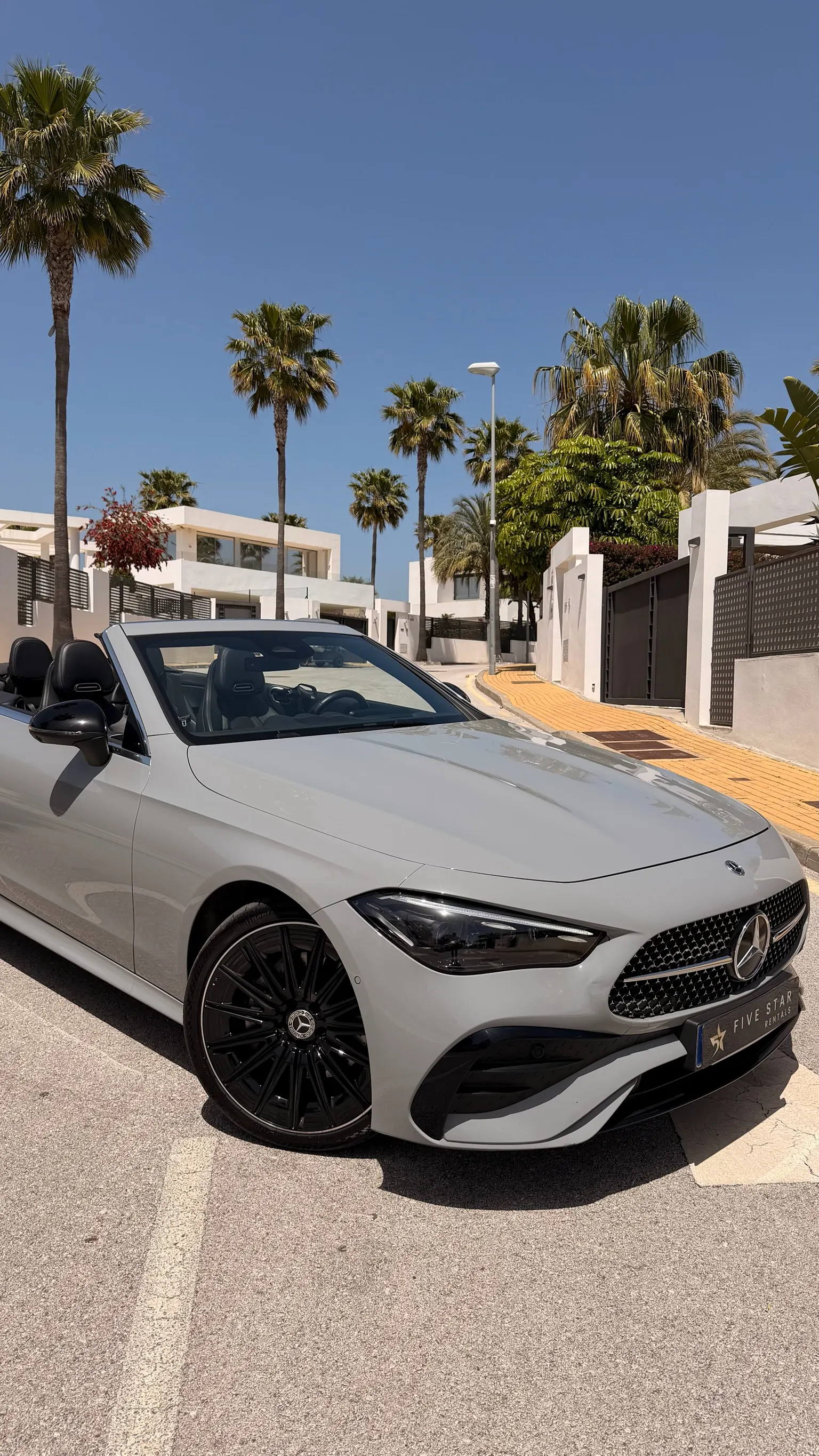 Mercedes-Benz CLE 200 Cabriolet close-up front three-quarter view with diamond-star grille, LED Multibeam headlights and 19-inch black AMG wheel
