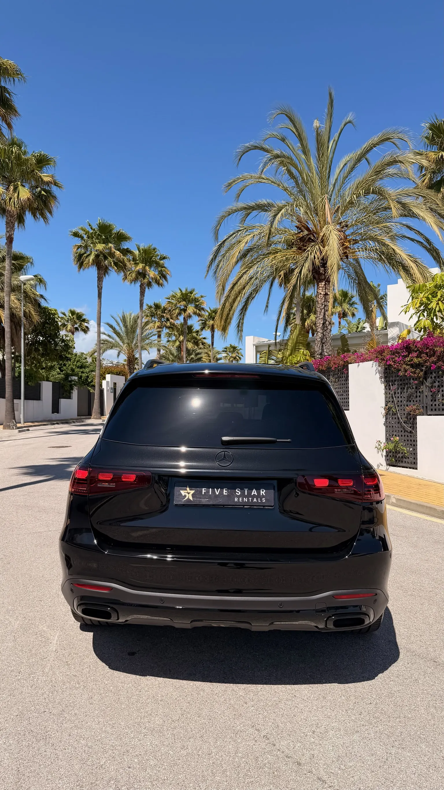 Side profile of the Obsidian Black Metallic Mercedes-Benz GLS 580 with 22-inch AMG multi-spoke gloss black wheel with chrome trim and panoramic roof