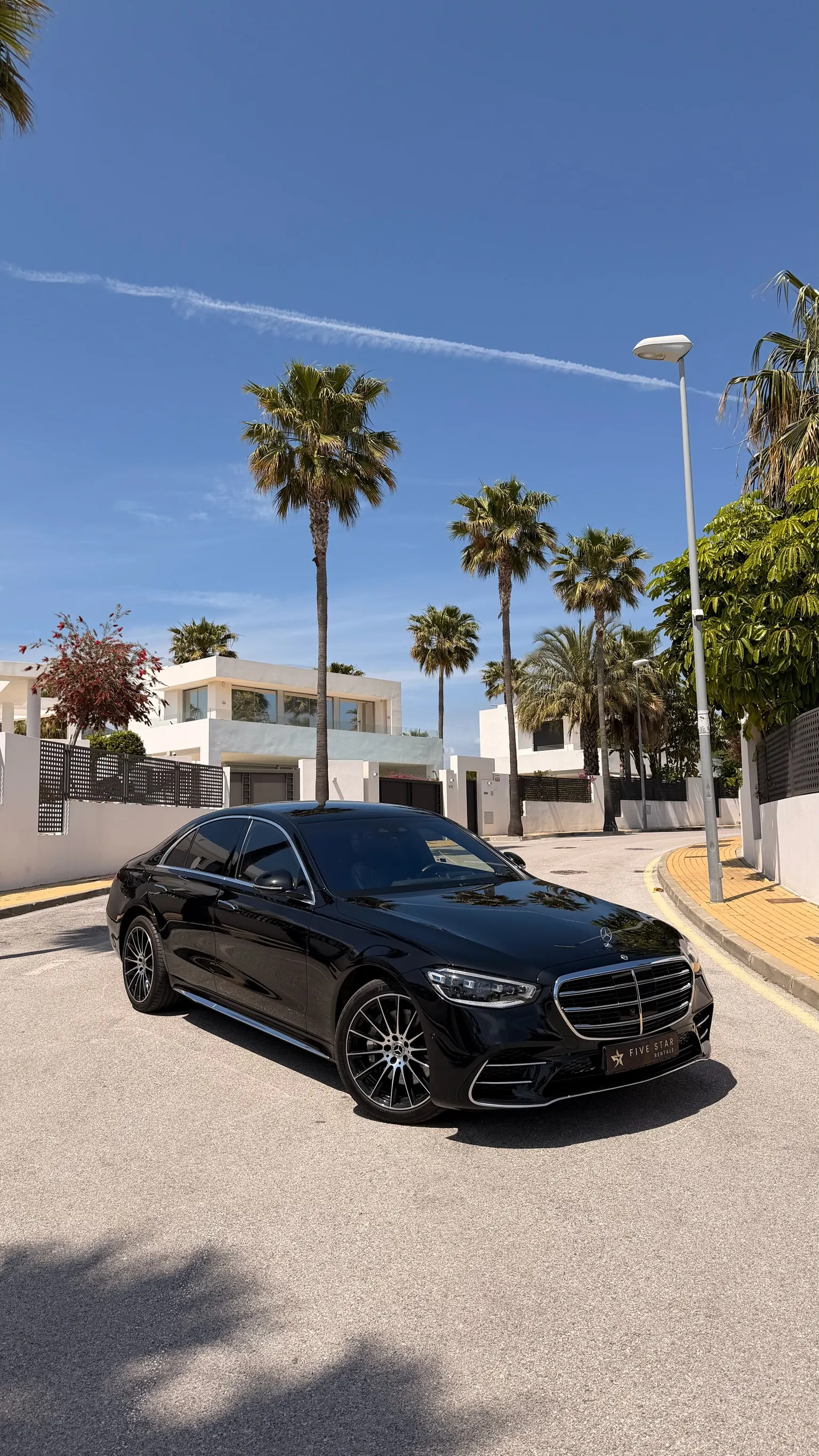 Mercedes-Benz Clase S 580 e negro Obsidiana, vista 3/4 delantera con parrilla cromada, matrícula Five Star Rentals y palmeras de Marbella