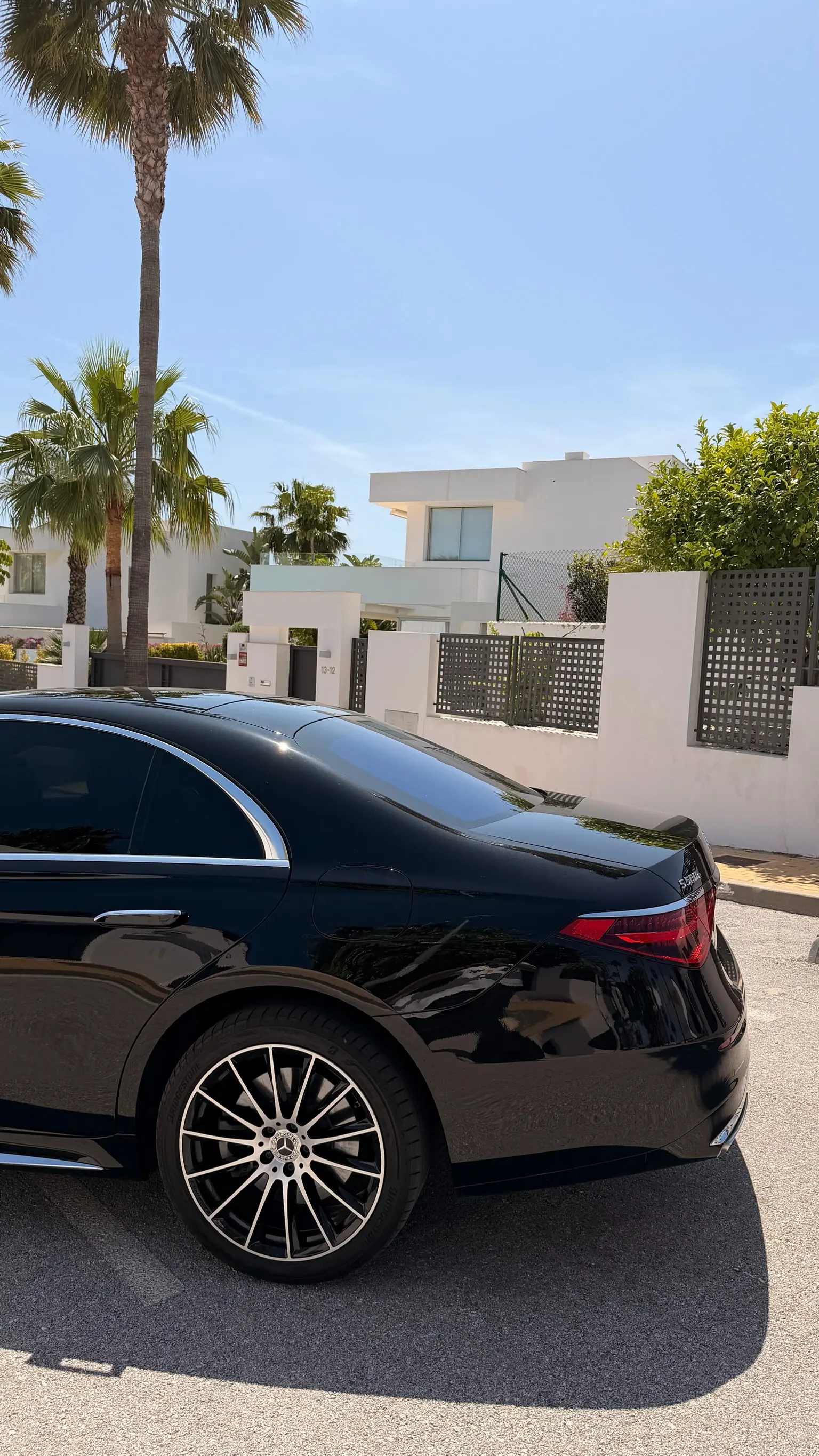 Perfil trasero del Mercedes-Benz S 580 e negro Obsidiana con llanta multibrazos bicolor, líneas limpias W223 y puerta de carga oculta