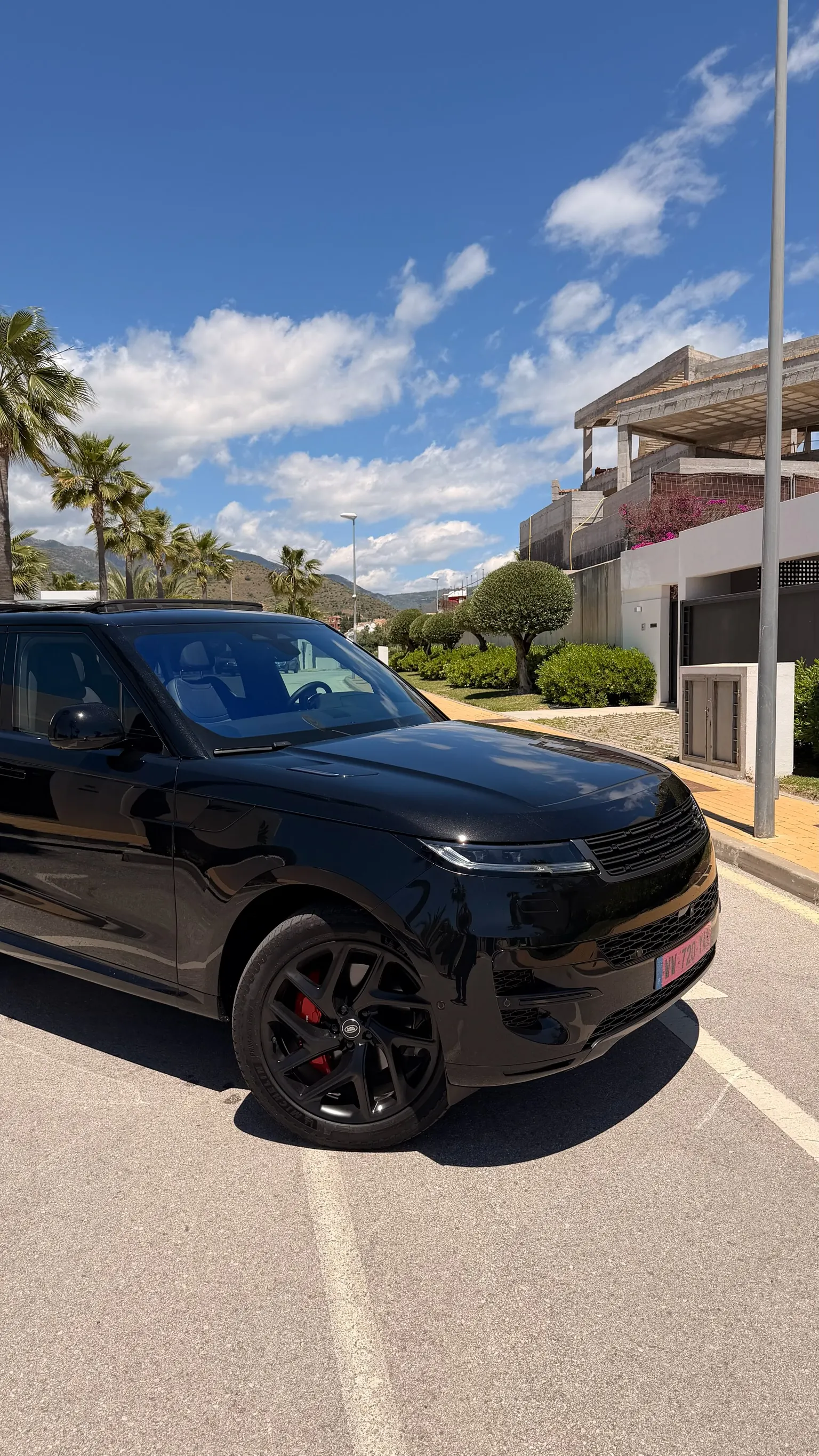 Range Rover Sport P460e vista 3/4 delantera de cerca con parrilla negra, faros LED estrechos firma L461 y llanta de 22 pulgadas multibrazos negra