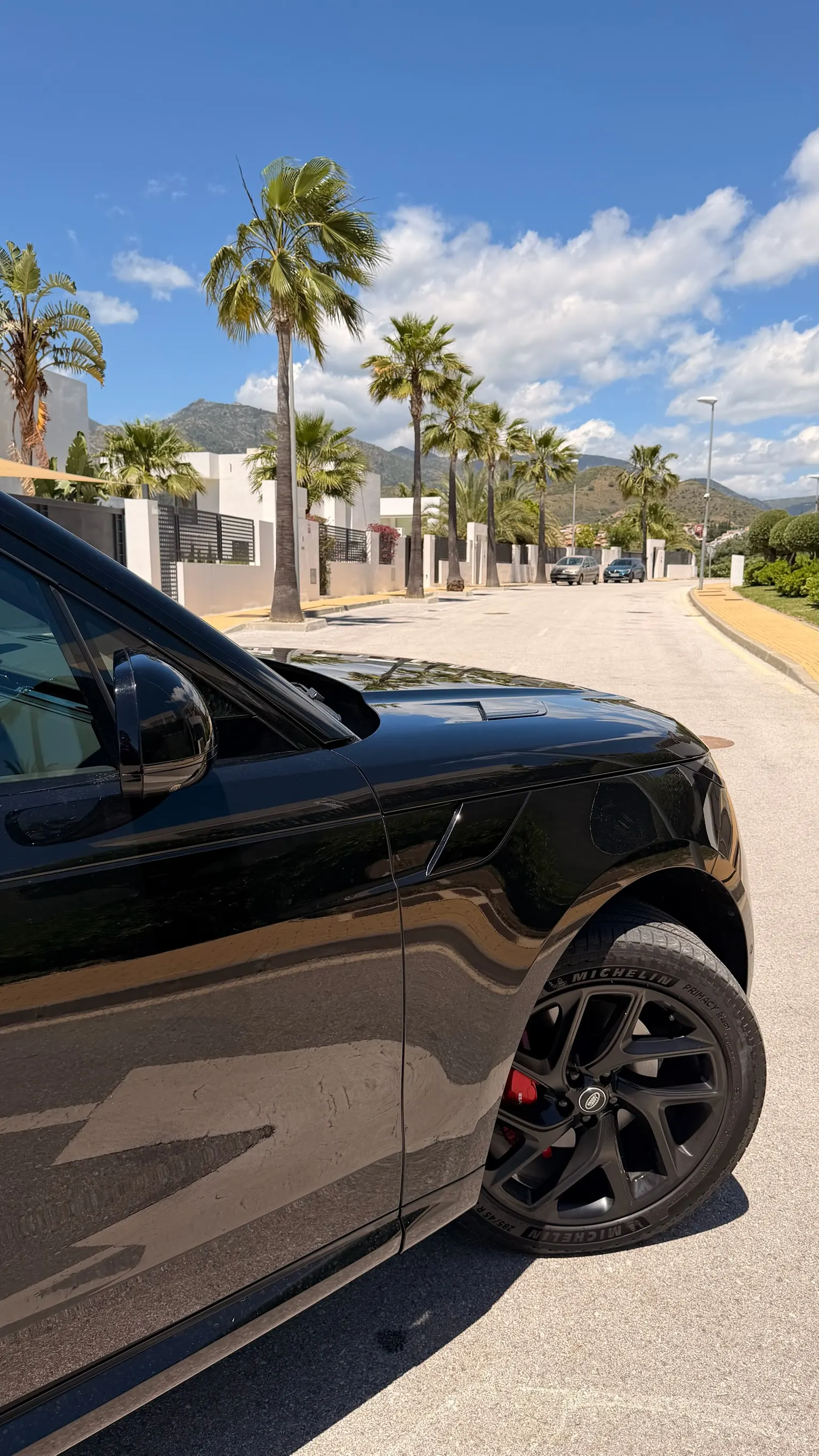 Detalle aleta delantera izquierda del Range Rover Sport con rejilla lateral negra firma, llanta de 22 pulgadas 5 radios estrellados y pinza de freno roja